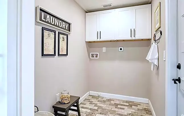 Laundry room featuring our Bright White Shaker wall cabinets for storage.