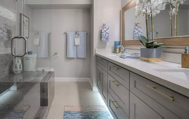 Castle Grey Shaker vanity cabinets with a mirror.