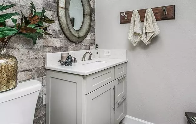 Dove Shaker vanity cabinets with stone backsplash.