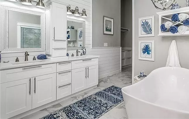 White Shaker double-sink vanity cabinet with large bath tub.